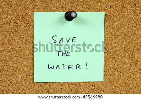 Green sticky note pinned to an office notice board. Save the water - environmental conservation and water saving info.