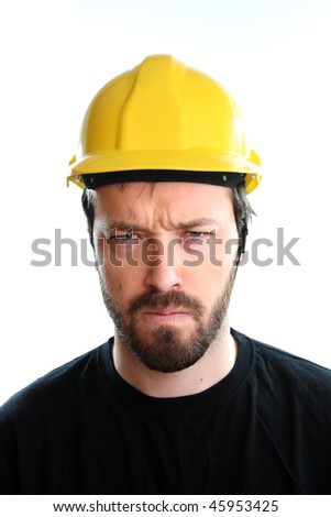Construction worker in yellow hard hat. Angry caucasian male in his 20s. Young man portrait.