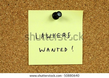 Yellow sticky note pinned to an office notice board. Lawyers wanted - legal career recruitment message.