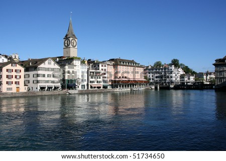 Zurich cityscape. St. Peter's Church tower with world's largest church clock face. Swiss city. Limmat river connecting with Lake Zurich.