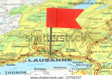 Lausanne - famous city in Switzerland. Red flag pin on an old map showing travel destination.