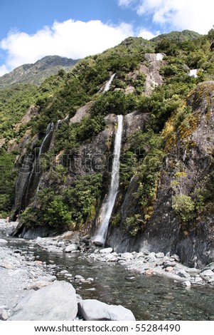 Westland National Park, New Zealand. Beautiful small waterfalls near Franz Josef Glacier. Temperate rainforest bush.