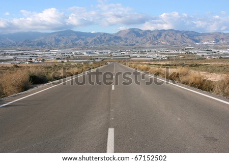 Road in Andalusia, Spain. Straight highway towards gigantic greenhouse farms.