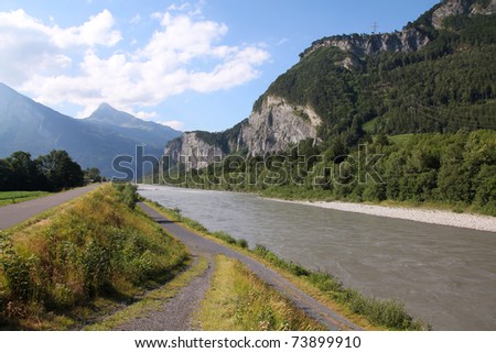 Cycle track along Rhine river in Switzerland. Mountain landscape.
