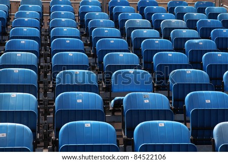Blue rows of chairs at an outdoor concert. Audience seats.