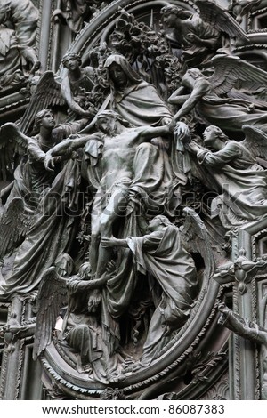 Milan Cathedral, Italy. Famous bronze door sculpture detail. Pieta - death of Jesus Christ.