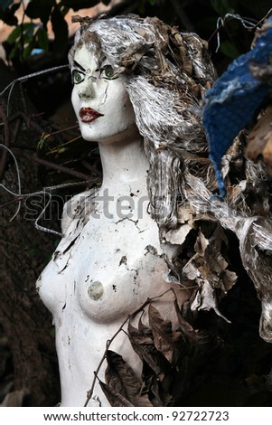 Creepy mannequin doll in an illegal garbage dump. Old manequin - mysterious horror atmosphere.