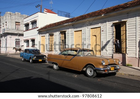CIENFUEGOS, CUBA - FEBRUARY 3: Classic old cars in the street on February 3, 2011 in Cienfuegos, Cuba. Recent law change allows Cubans to trade cars again. Old law resulted in very old cars in Cuba