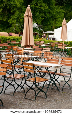 A German Beer Garden, With Chairs And Tables And Sunshades. Stock Photo