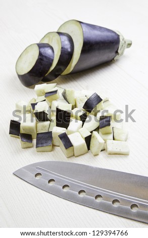 Eggplant and knife, detail of preparation of the plant, raw food in the kitchen, healthy eating
