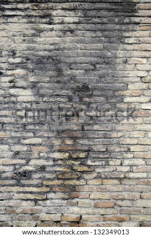 Old broken brick wall, detail of a textured background brick wall in a town