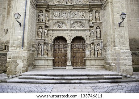 Facade of old medieval church, detail of a wooden door and gothic sculptures, City Tours