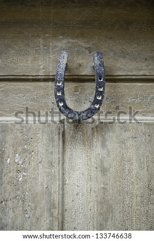 Wooden door with horseshoe detail of an old wooden door broken, luck and superstition