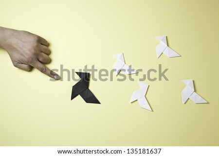 Hand pointing origami, detail of a hand pointing a paper figures, oriental art