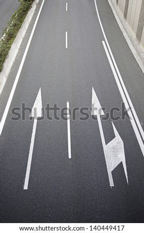Arrows on the asphalt, detail of a road in the city, asphalt textured background