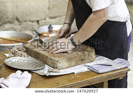 Chef cutting meat, detail of a worker cooked meat cooking
