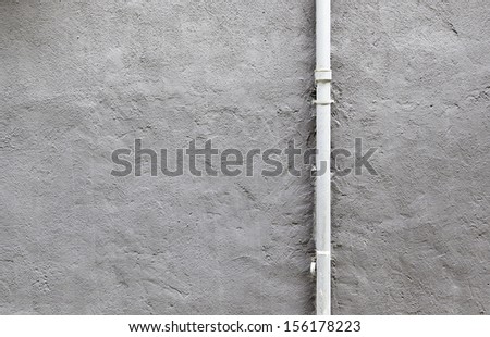 Pipe cement wall, detail of a wall painted with a metal pipe, outdoor exploration