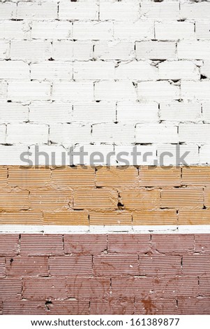 Brick Wall with colors, detail of an old wall painted red and white, neglect and ruin