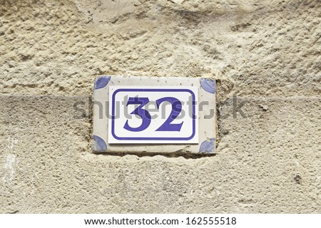 Number thirty-two on the wall, detail of a number in a house in the city