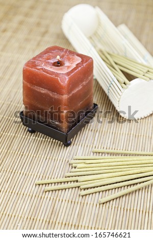 Red candle with incense and bamboo detail of decoration spa, relaxation and aroma, oriental culture