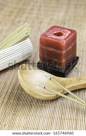 Red candle with incense and bamboo detail decoration spa, relaxation and aroma, oriental culture
