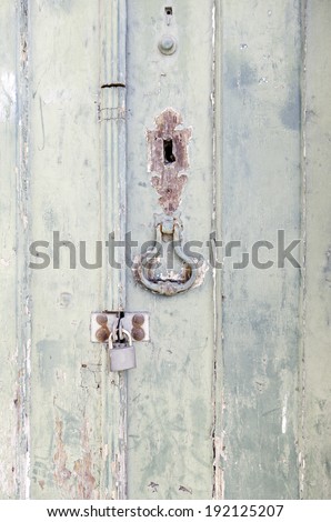 Door closed with wooden decoration, detail of a closed door with padlock, protection and security