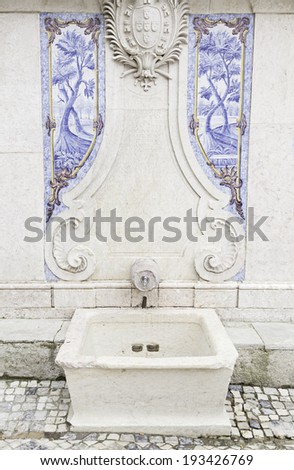 Old stone fountain, detail of a fountain with decorative tiles, ancient monument
