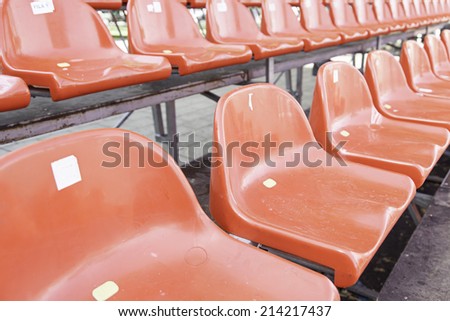 Red seats in a grandstand, detail of seats in a football field, spectators and sport