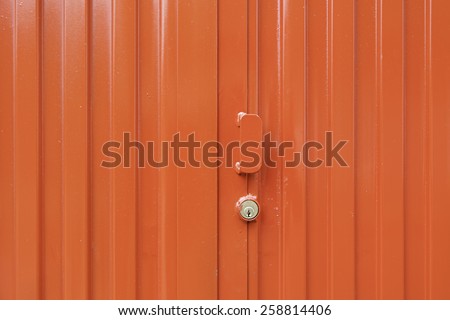 Red metal door, detail of a closed door painted red, protection and security