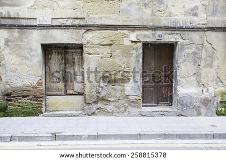 Old wooden door wall, detail of a building in ruins and abandoned
