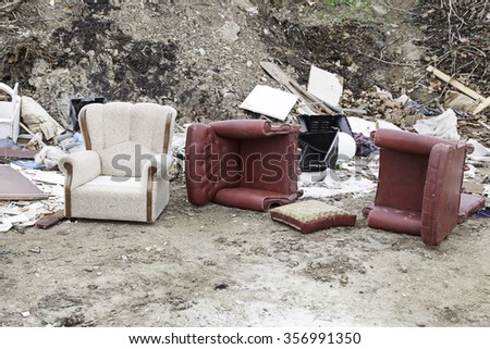 Sofas broken and abandoned, detail of furnishings from left, dirt and debris