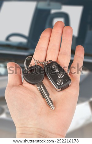 car key with alarm in hand over auto