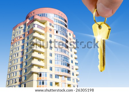 real estate concept. gold keys in fingers with building