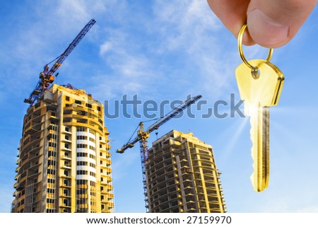 construction concept. gold keys in fingers with houses