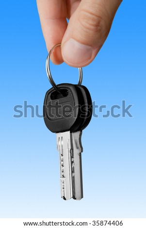 keys in fingers over blue background. mortgage concept
