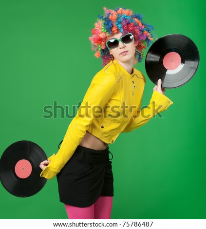 The girl in a color wig with a disk on green background