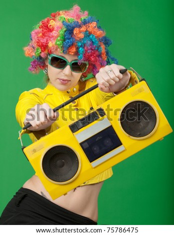 The girl in a color wig with the old tape recorder on green background