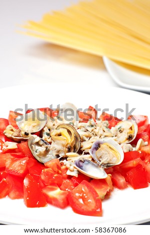 sauce with fresh tomatoes and clams, in second place on a plate of raw spahetti