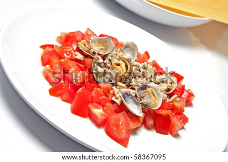 sauce with fresh tomatoes and clams, in second place on a plate of raw spahetti