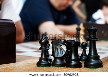 Chess pieces in the foreground during a game of chess