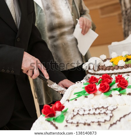 a man with the knife cut of a wedding cake