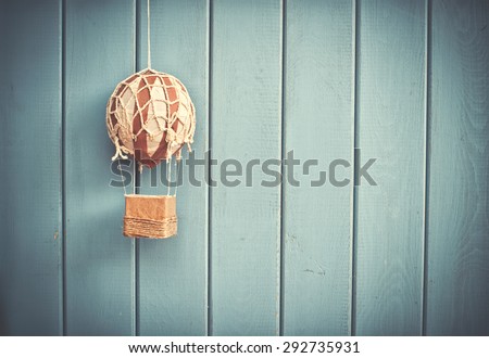 Vintage toy air balloon hanging on blue wooden wall