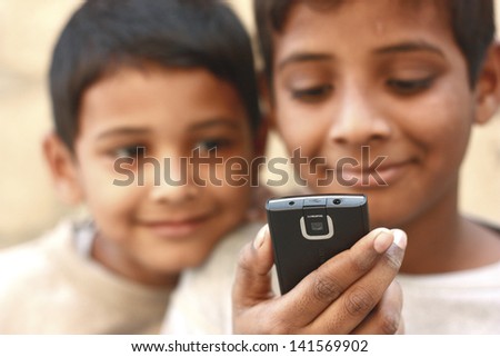 Asian boy playing on mobile phone and the brother looking on phone