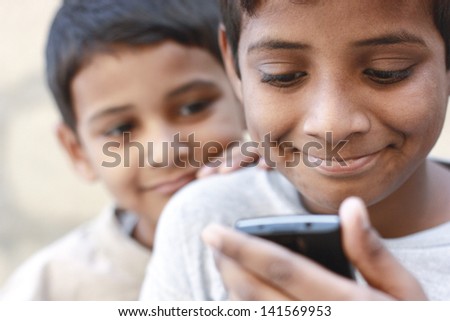 Asian boy playing on mobile phone and the brother looking on phone