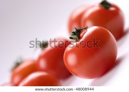 Closeup of red tomatoes, First one clearest, the ones in the background not as clear
