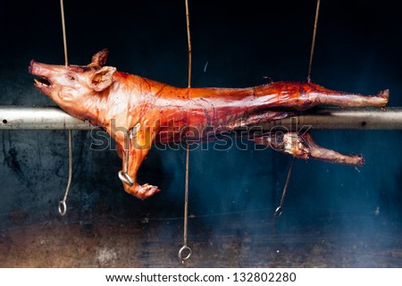 Red roasted pig on a traditional spit