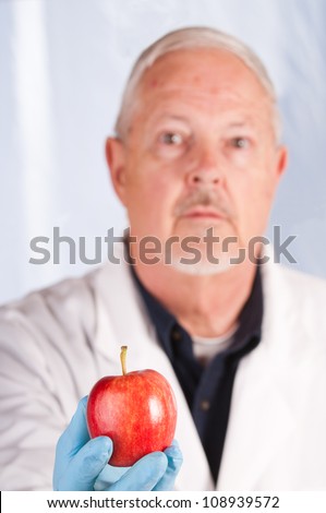 Doctor holding out an apple suggesting the old adage \
