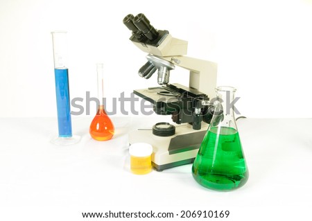 Red, green and blue liquids in medical flasks of different shapes and sizes with a microscope