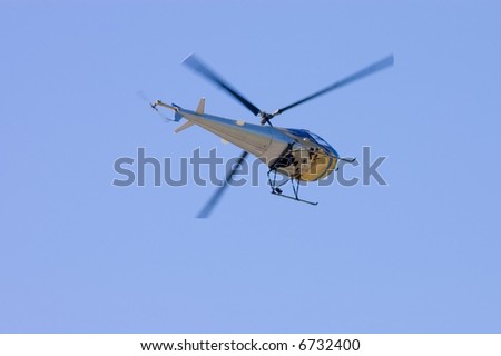 Helicopter frozen in time with rotors captured with illustrating some movement at the tips