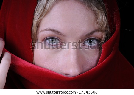 Beautiful blond woman in closeup with red velvet shawl or scarf over head